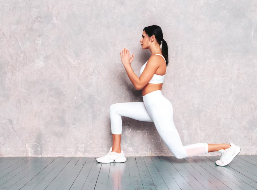 woman in white sport suit doing yoga near the gray wall